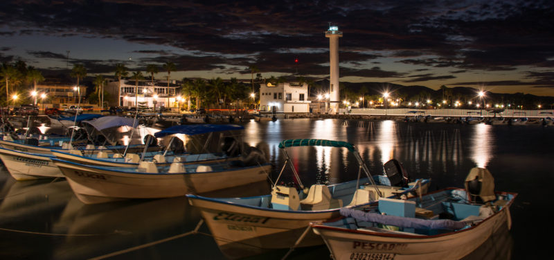 DSC_0564-5 (boats at night) slider Fishing boats docked at night with light tower, beach, buildings, and lights in the background