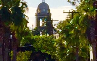 Tree lined street with Mission building in the distance